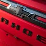 A red 2021 Chevy Tahoe RST's black bow tie logo is shown.