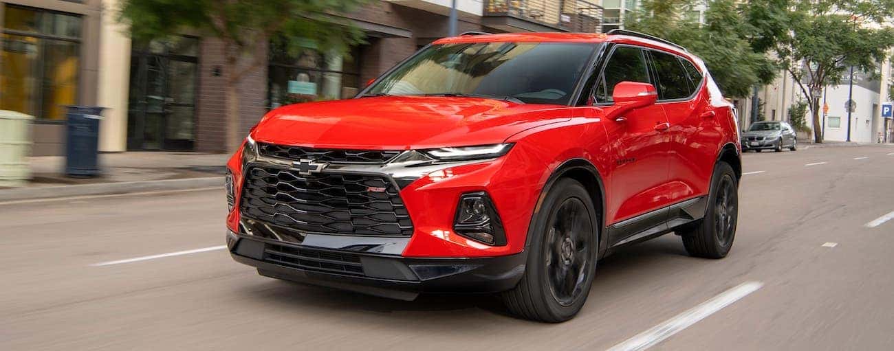 A red 2020 Chevy Blazer RS is driving on a city street outside of Albany, NY.