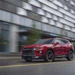 Red 2021 Chevrolet Blazer SUV driving past a tall grey building