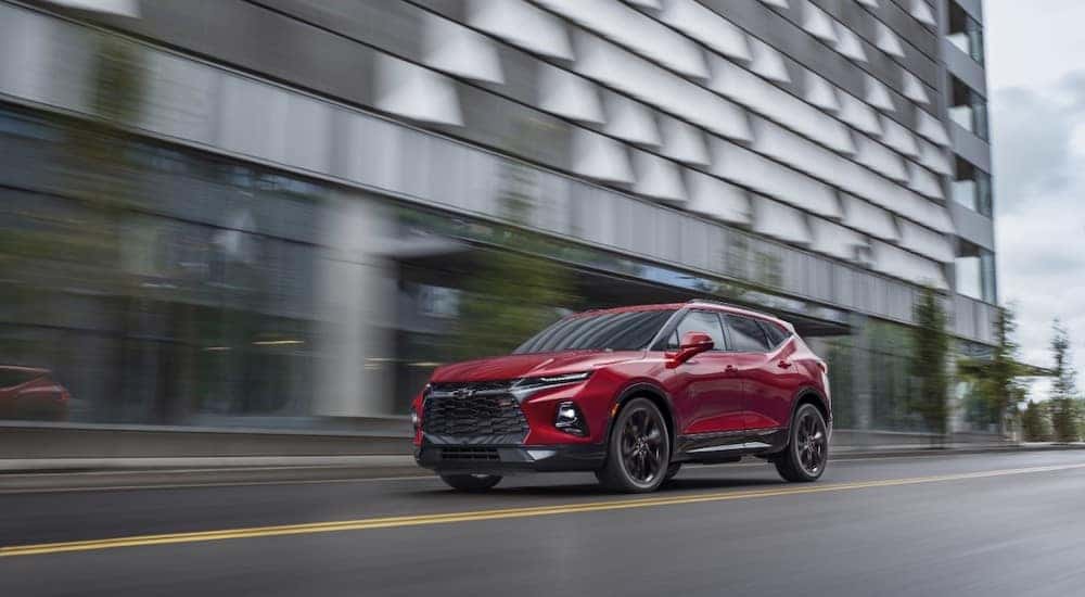 Red 2021 Chevrolet Blazer SUV driving past a tall grey building
