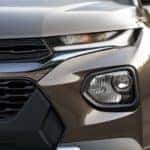 A closeup of a new Chevy vehicle, a brown 2021 Chevy Trailblazer, is shown from the front.