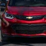 A red 2020 Chevy Bolt EV is shown from the front, parked on a street in Clifton Park, NY.