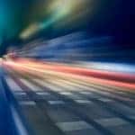 Blurred car lights on a paved road in the dark night