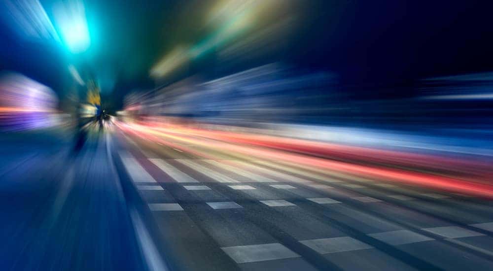 Blurred car lights on a paved road in the dark night