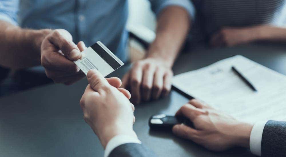 A couple is paying with credit card at a Chevy dealership near Clifton Park, NY.