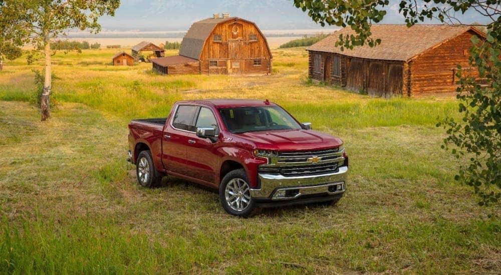 A red 2020 Chevy Silverado 1500 LTZ is parked in front of barns.