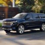 A blue 2021 Chevy Suburban is driving on a neighborhood street after leaving a Chevy dealership near Clifton Park, NY.
