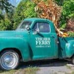 An antique green truck full of fall decorations is shown with Vischer Ferry General Store printed on the side.