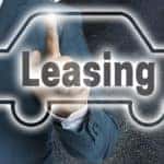 Man in a suit with his pointer finger out, touching the floating black and white outline of a vehicle with the word "Leasing" inside it