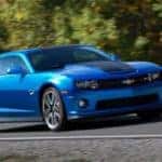 Blue and black Chevrolet Camaro Hot Wheels sports car driving down a paved road