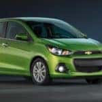 Lime green 2016 Chevrolet Spark hatchback parked in an all-black room