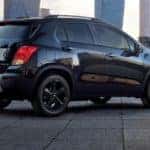 Black 2016 Chevrolet Trax SUV parked diagonally toward tall city buildings