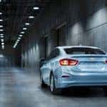 Back to front view of a silver 2017 Chevrolet Cruze sedan in a grey tunnel with overhead lights