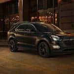 Black 2017 Chevrolet Equinox parked on the side of a paved road at a storefront
