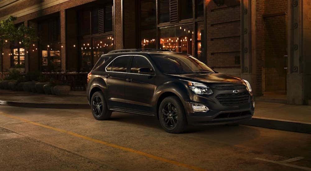 Black 2017 Chevrolet Equinox parked on the side of a paved road at a storefront