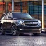 Black 2017 Chevrolet Tahoe parked on a black brick floor in front of a glass building