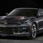 Black and red 50th Anniversary Camaro sports car parked in an all-black room