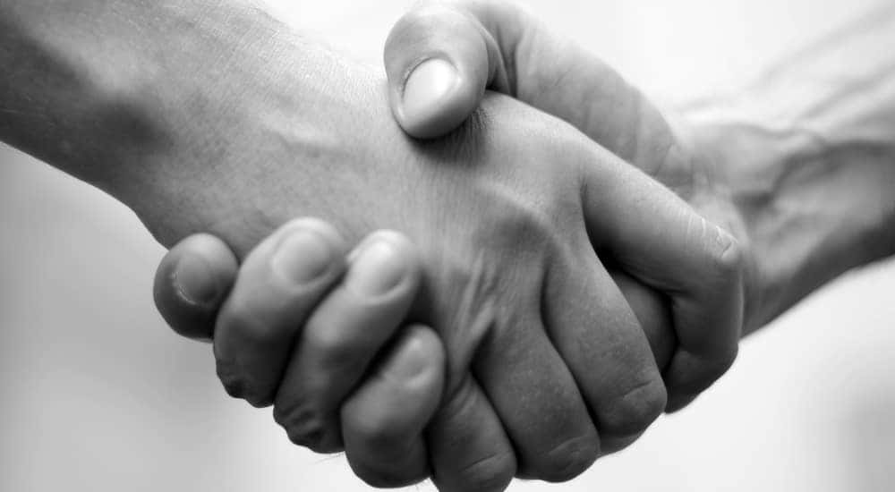 Black and white close-up of two people shaking hands