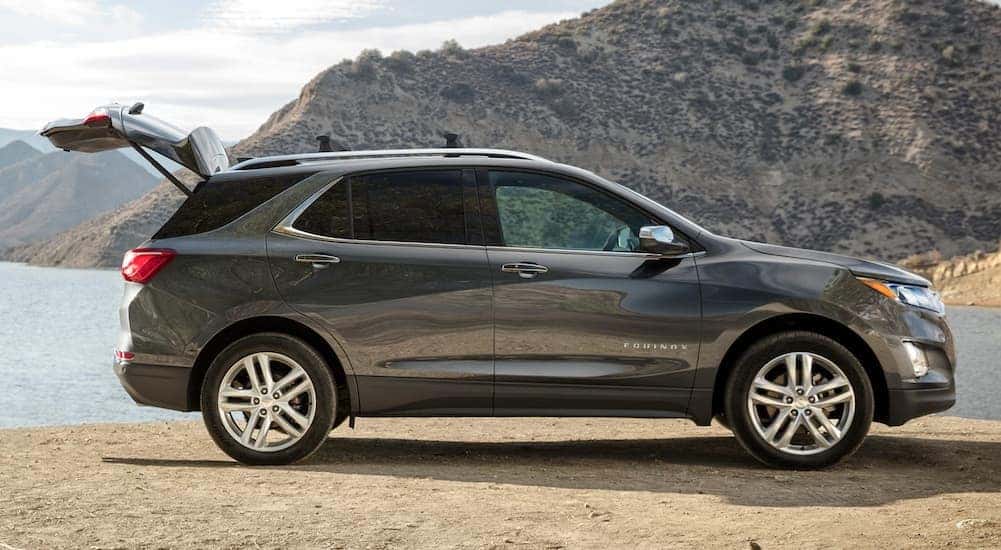 A silver 2020 Chevy Equinox is parked on the sand with its hatch open.