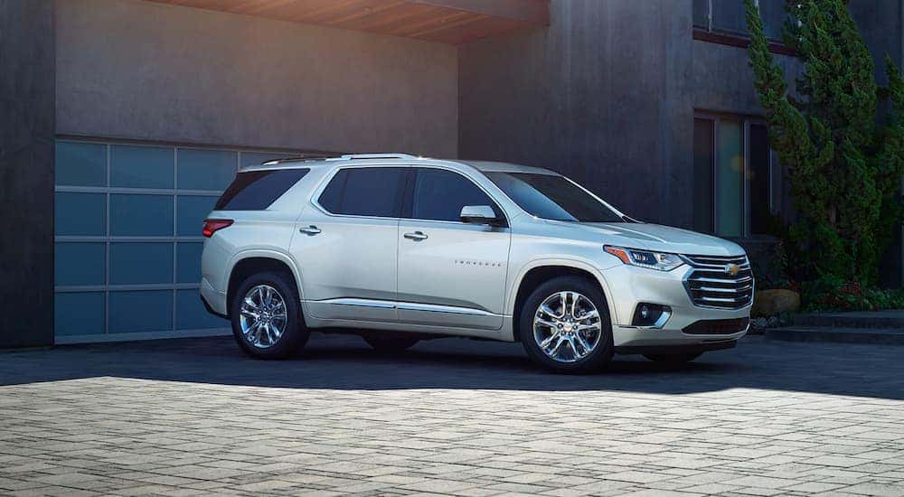A silver 2020 Chevy Traverse is parked in front of a modern house after leaving the Chevy dealership near Clifton Park, NY.