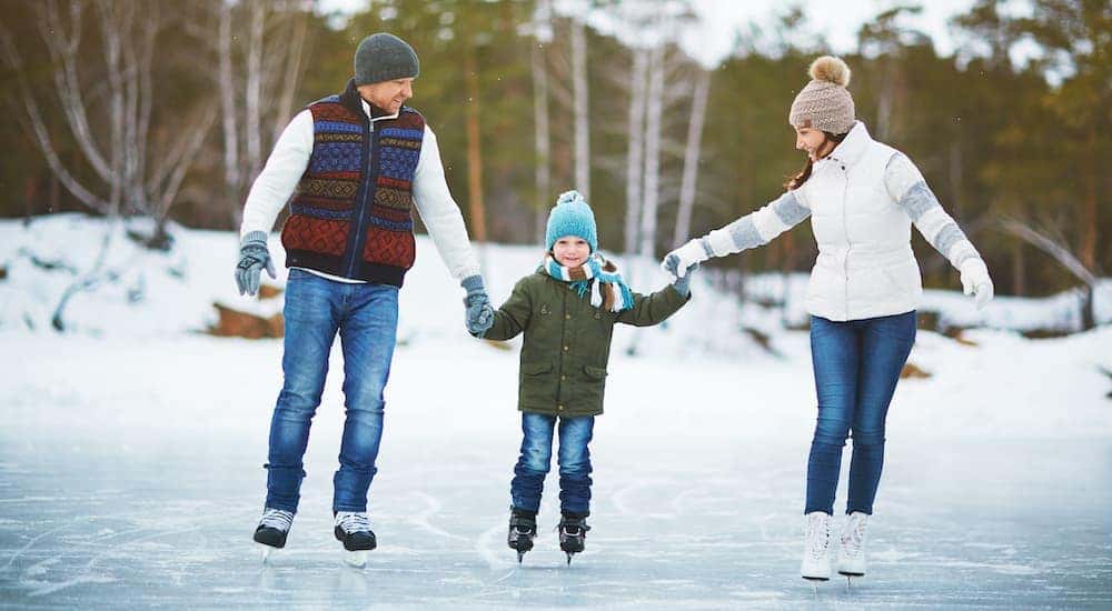 A family is holding hands while ice skating.