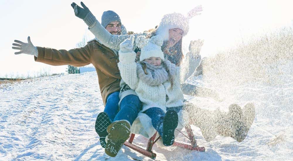A family is sliding down a hill on a toboggan in Clifton in Park, NY.