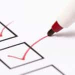 Red checks in black boxes on an all-white piece of paper