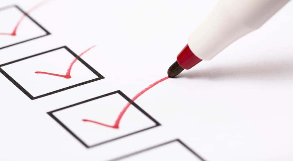 Red checks in black boxes on an all-white piece of paper