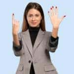 Businesswoman in a blazer holding up six fingers against a blue background