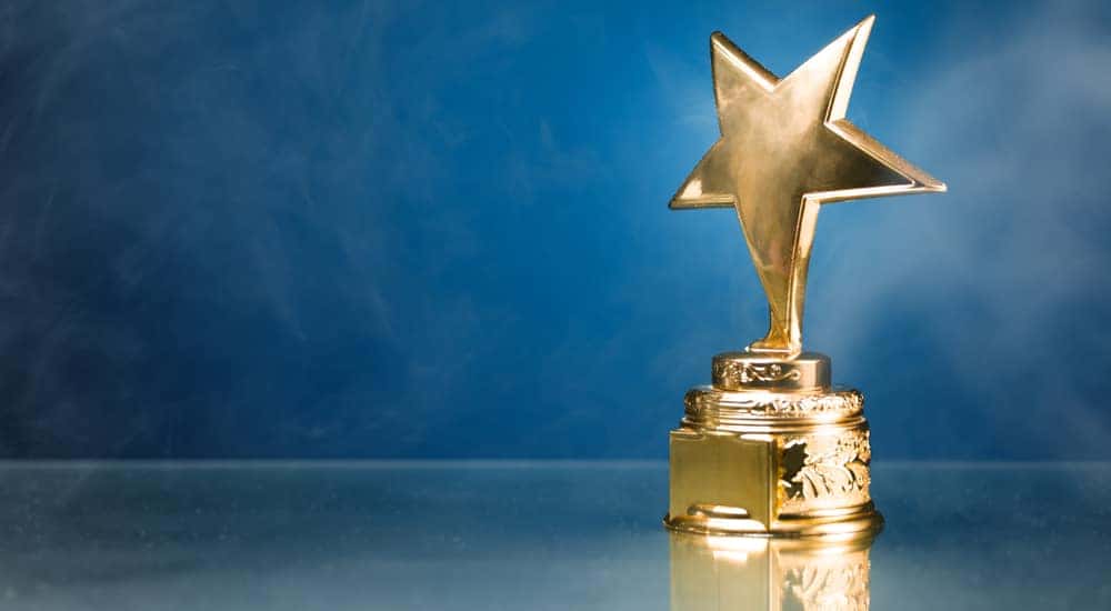 Gold star trophy in smoke against a blue wall