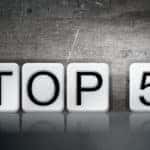 The words "TOP 5" written in vintage metal letterpress type in front of a soft backlit background