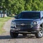 Dark-colored 2016 Chevrolet Tahoe SUV parked on a dirt path surrounded by grass