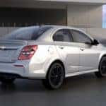 Silver 2018 Chevrolet Sonic parked on cement next to a cement building