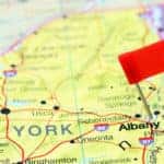 Albany NY marked with a red flag on a yellow, blue, orange, and purple map