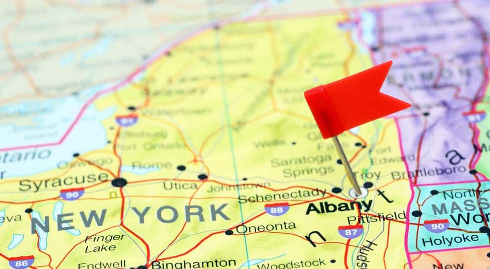 Albany NY marked with a red flag on a yellow, blue, orange, and purple map
