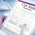 Hands holding a tablet with a car loan application on the screen