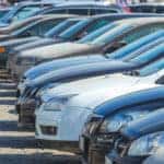 Multiple colors of vehicles parked in a used car lot