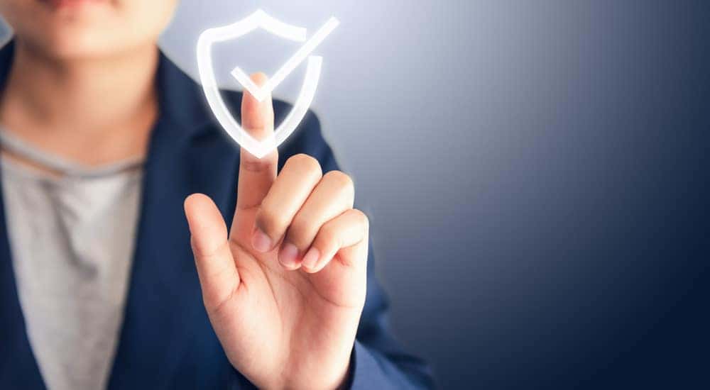 Man in a blue blazer holding his finger out to touch a floating white checkmark
