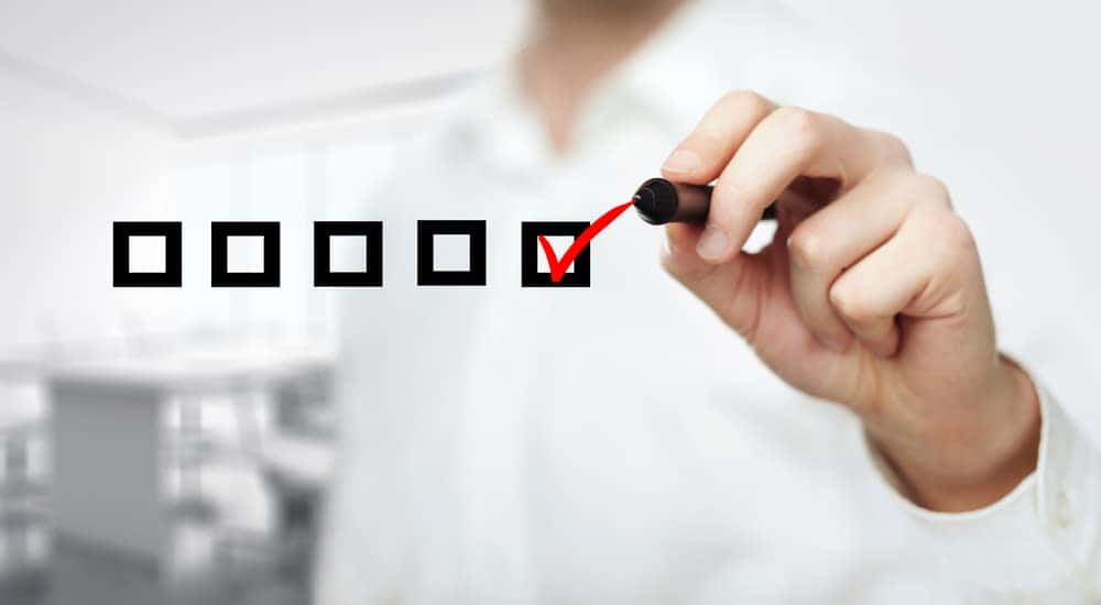 Man in a white button up checking off floating black boxes with a red marker