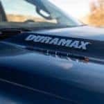 A closeup shows the Duramax badging on a blue 2020 Chevy Silverado 1500 diesel.