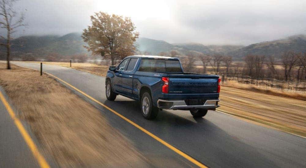 A blue Chevy diesel truck for sale near you driving on highway