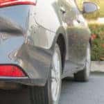 Close-up in a rear dent on a grey sedan