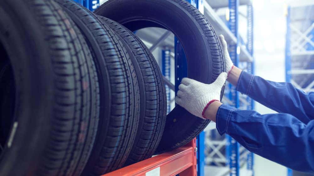 Man grabbing a tire off a shelf at the Chevy parts center