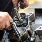 Hands working on transmission repairs