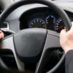 Hands on a black steering wheel
