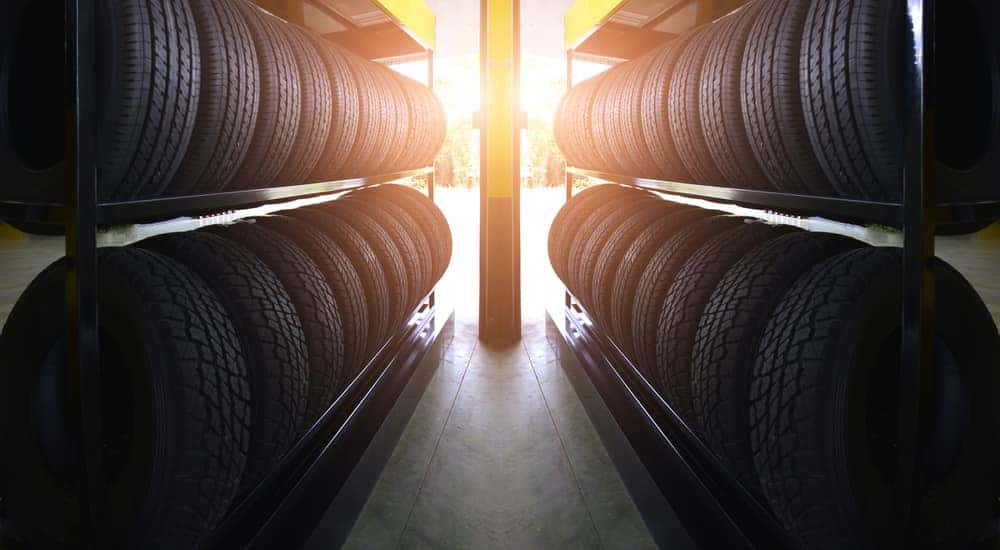 Shelves of tires in front of a yellow post with sunlight peeking through