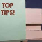Blue sticky note with the words "TOP TIPS!" written on it and the numbers one to three up against a stack of books