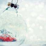 Red toy car inside a clear glass ornament sitting in snow
