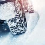 Tires and bottom half of a vehicle in the snow
