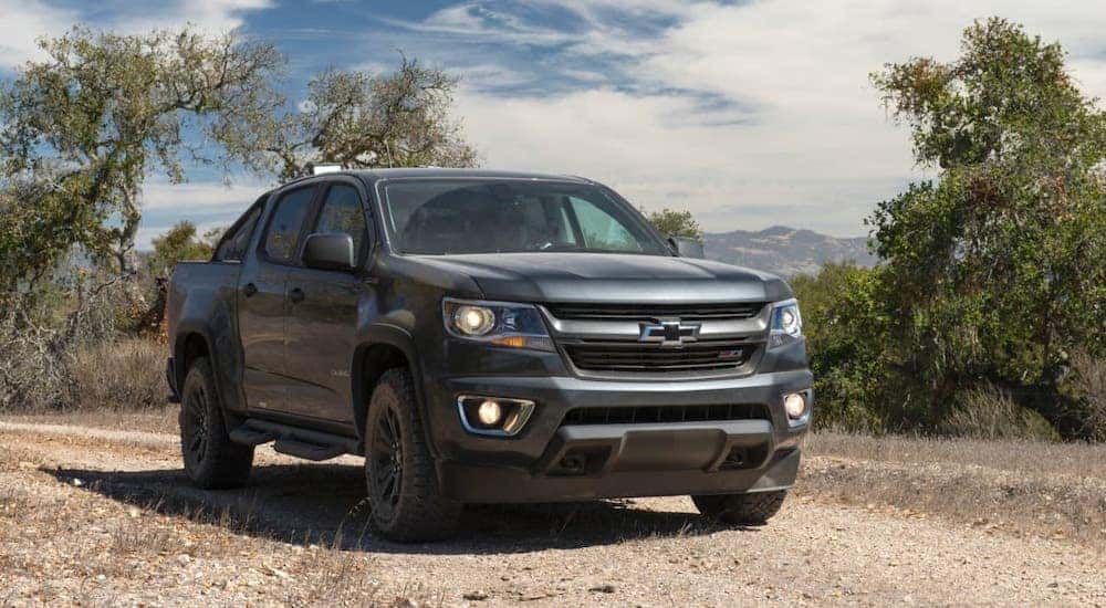 A black 2016 Chevy Colorado is parked on a dirt trail after leaving a used car dealer in Albany.